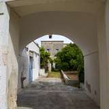 Attraverso un arco tufaceo bianco accediamo al cortile